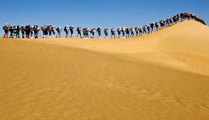 Цепочка туристов на бархане в Сахаре